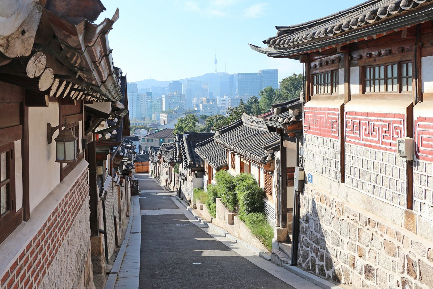 A hanok alley in Bukchon Hanok Village with N Seoul Tower in the distance
